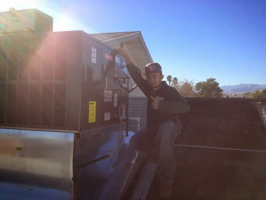 HVAC technician performing AC Tune-Up on a rooftop unit in Braidwood